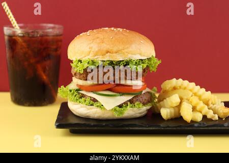 Double Patty Burger with Fries and Cola on Yellow and Red Background, Fast Food Concept Stock Photo