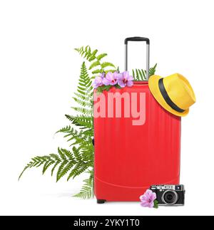 Red travel suitcase, camera, hat, tropical leaves and flowers on white background Stock Photo