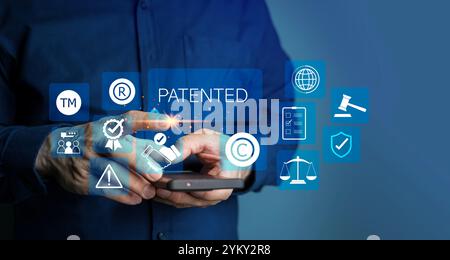 Patented patent copyright law business technology concept. businessman touch virtual screen of patented word with copyright icons for author rights an Stock Photo