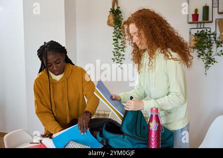 Students preparing backpacks for school together at home Stock Photo