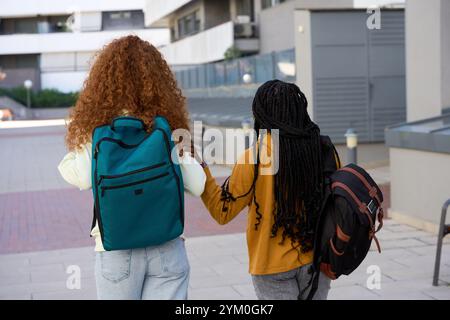 Two female students walking together on campus after class Stock Photo
