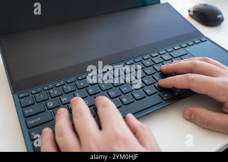 A man using a laptop with a colored green screen. Sunlight falls on the laptop keyboard. With space to copy. High quality photo Stock Photo