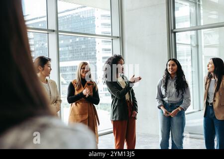 Group of businesswomen collaborating and discussing ideas in a modern office environment. Perfect for teamwork, office culture, and women in business Stock Photo