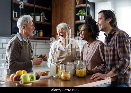 Multi generation multiethnic family having fun, talking around a festive kitchen table. Stock Photo