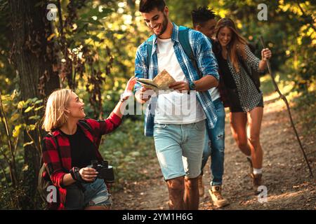 Group of four friends having fun hiking through forest together. Stock Photo