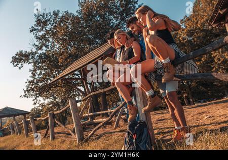 Group of four friends having fun hiking through forest together. Stock Photo
