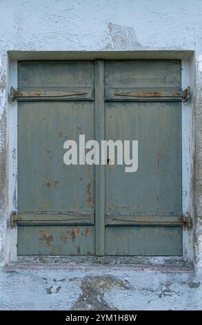 Window with closed green shutters on an old weathered house, Bavaria, Germany Stock Photo