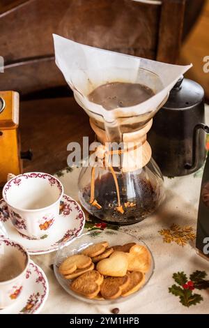 Pour over filter coffee alternative brewing method. Girl is pouring hot water over roasted and ground coffee beans contained in paper filter. Ceramic Stock Photo