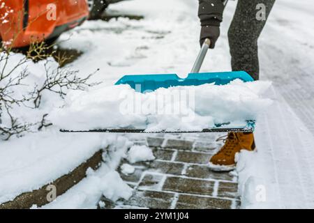 Removing snow from sidewalk, snow shoveling Stock Photo