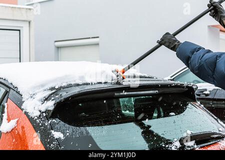 Cleaning and scraping windscreen from snow Stock Photo