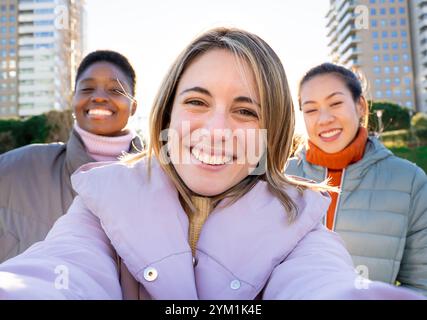 Three girls taking a selfie portrait happy looking at camera. Stock Photo