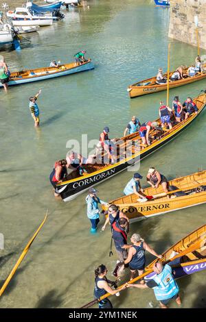 Pilot Gig crews carrying their oars waiting to board their Pilot Gigs for Women's Newquay County Championships Cornish Pilot Gig Rowing event at Newqu Stock Photo