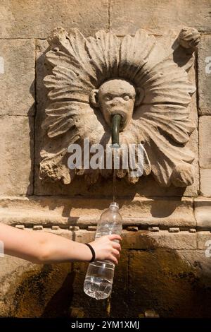 Young girl fills water bottle from monkey sculpture facemask outlet on Large Onofrio Fountain / Big Onofrios Fountains. Poljana Paska Miličevića sqare. Dubrovnik old town. Croatia. (138) Stock Photo