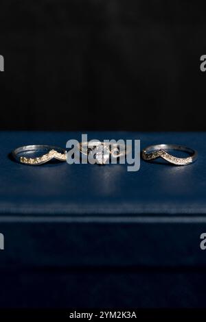 Photograph of three rings on a blue box with a black background Stock Photo