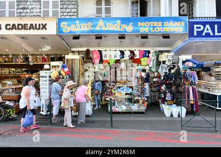 Religious Souvenir Shops or Christian Gift Stores with Tourists or Pilgrims in Lourdes Hautes-Pyrénées France Stock Photo