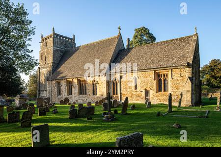 Evening light on the 12th century church of St Laurence in the Cotswold village of Wyck Rissington, Gloucestershire, England UK Stock Photo