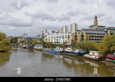 The River Thames as viewed from Kew bridge looking towards Brentford riverside with moored houseboats and modern apartments Greater London England UK Stock Photo