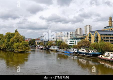 The River Thames as viewed from Kew bridge looking towards Brentford riverside with moored houseboats and modern apartments Greater London England UK Stock Photo