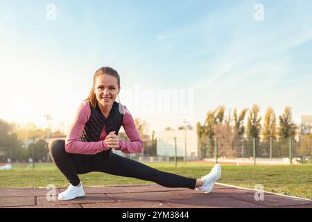 Young woman doing stretching exercises during an outdoor workout. Stock Photo