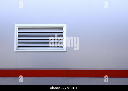 Air ventilator, metal slat frame on gray wall background. Stock Photo