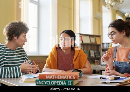 Engaging in Group Study in Comfortably Lit Library Stock Photo