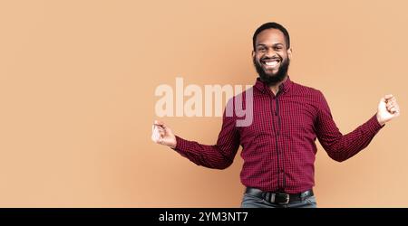 Happy black guy jumping and looking at camera Stock Photo