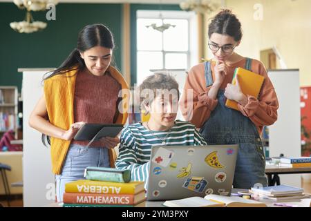 Collaborating Students Working on Laptops in Library Stock Photo