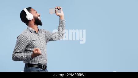 Afro man singing using smartphone as microphone Stock Photo