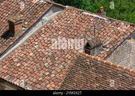 Traditional orange handmade French roof tiles on roofs in France. On the left the so-called tuiles canal and on the roof on the right the tuiles plate Stock Photo