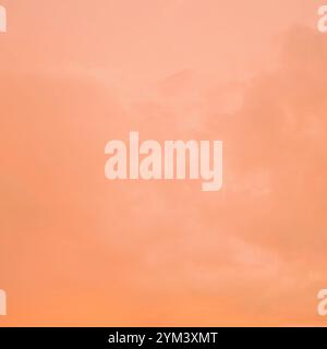 A bright and beautiful orange sky with clouds at dawn creates a heavenly backdrop. Stock Photo