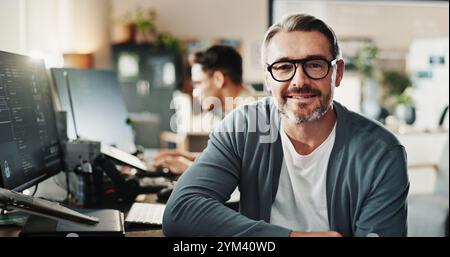 Man, coder and glasses in office for portrait, website development and software engineering at tech. Mature programmer, smile and pride in agency for Stock Photo