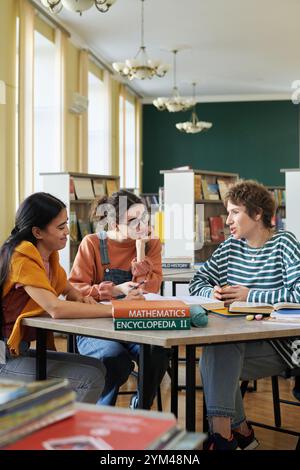 Students Collaborating in a Library for a Group Project Stock Photo