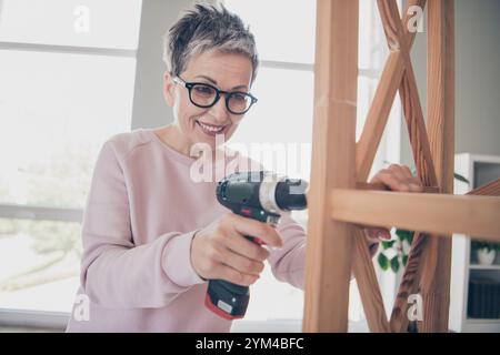 Photo of adorable sweet lady wear pink sweatshirt fixing furniture indoors room home house Stock Photo