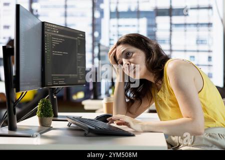 Tired programmer falling asleep while conducting tests to optimize machine learning models for performance and accuracy. Exhausted IT expert struggling to stay awake in office while analyzing data Stock Photo