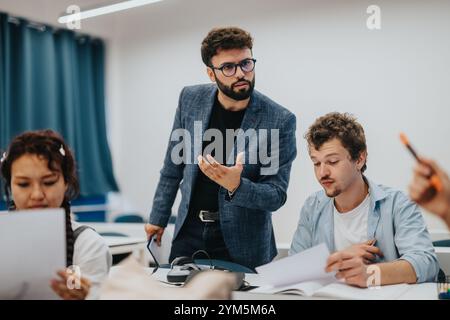 Professor assists students during an engaging classroom session Stock Photo