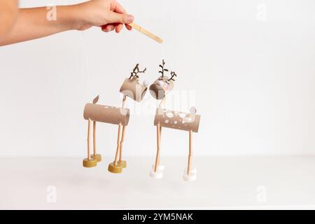 controlling DIY reindeer puppets made from cardboard tubes and bottle caps. Christmas and winter holiday craft concept. recycle paper Stock Photo