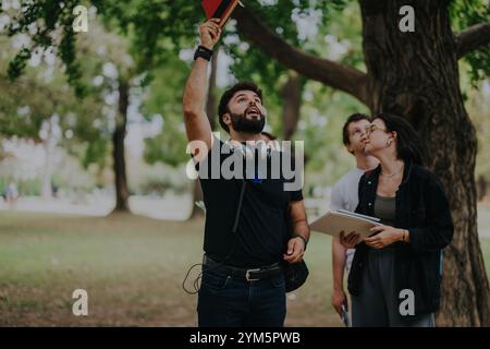 Multicultural students collaborating on projects in a park setting Stock Photo