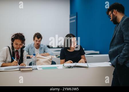 Professor assisting students during interactive classroom session Stock Photo