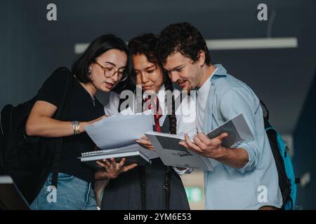 Engaged students discussing assignments with professor in a college hallway Stock Photo