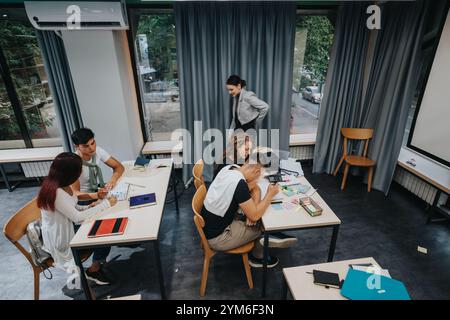 Students collaborating on a group project in modern classroom setting Stock Photo