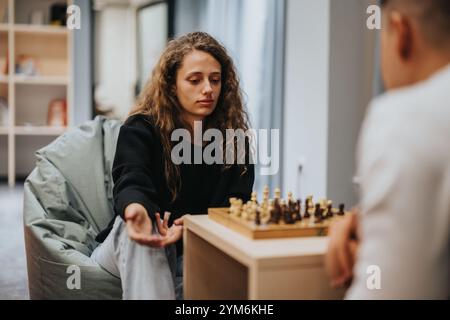 Teenagers engage in a thoughtful chess game at school Stock Photo