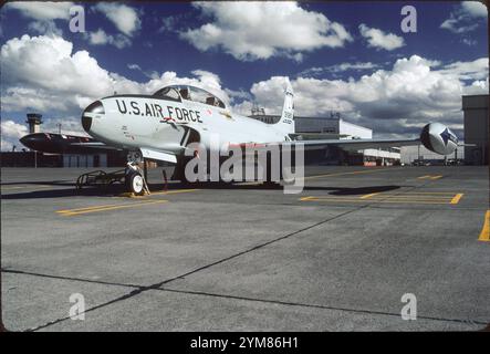 T-33A beauty shot. Clean lines of Lockheed T-Bird stand out, on the Montana ANG ramp at Great Falls IAP on a typical sunny day.  Tip tanks were a necessity due to the reduction in fuselage tank capacity from the P-80 to fit the rear cockpit. Note speed brakes and flaps beneath fuselage and wings. Stock Photo