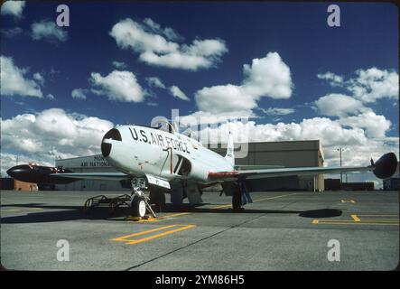 T-33A beauty shot. Clean lines of Lockheed T-Bird stand out, on the Montana ANG ramp at Great Falls IAP on a typical sunny day.  Tip tanks were a necessity due to the reduction in fuselage tank capacity from the P-80 to fit the rear cockpit. Note speed brakes and flaps beneath fuselage and wings. Stock Photo