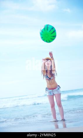 Woman playing beach volleyball on beach Stock Photo