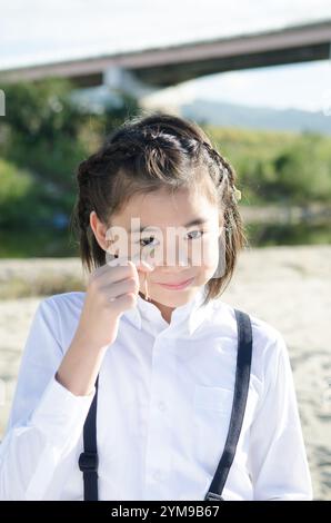 Primary school girl holding a twin leaf Stock Photo