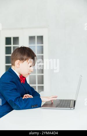 Schoolboy In Business Suit Studying Online With Laptop Stock Photo