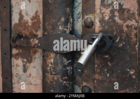 A metal padlock on the aged, rusty, abandoned metal gate. Old padlock, Door, Close up, Vintage style, Rusty Stock Photo