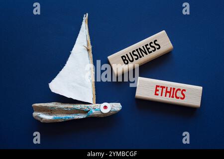 Business ethics symbol. Concept word Business ethics on wooden blocks. Beautiful deep blue background with boat. Business and Business ethics concept. Stock Photo