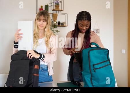 Multiethnic students preparing backpacks at home Stock Photo