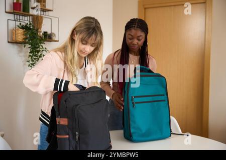 Multiethnic students preparing backpacks at home Stock Photo